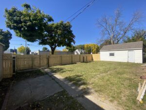 A newly installed wooden privacy fence in a backyard by RT Property Services in Allendale, MI