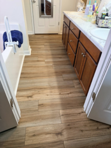Stylish wood-look plank flooring installed in a bathroom with a vanity by Master Renovations LLC in Englewood, CO.
