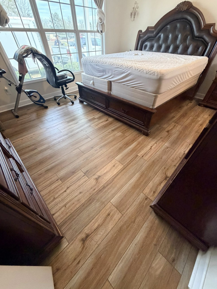 Freshly installed wood-look plank flooring in a bedroom by Master Renovations LLC in Englewood, CO.