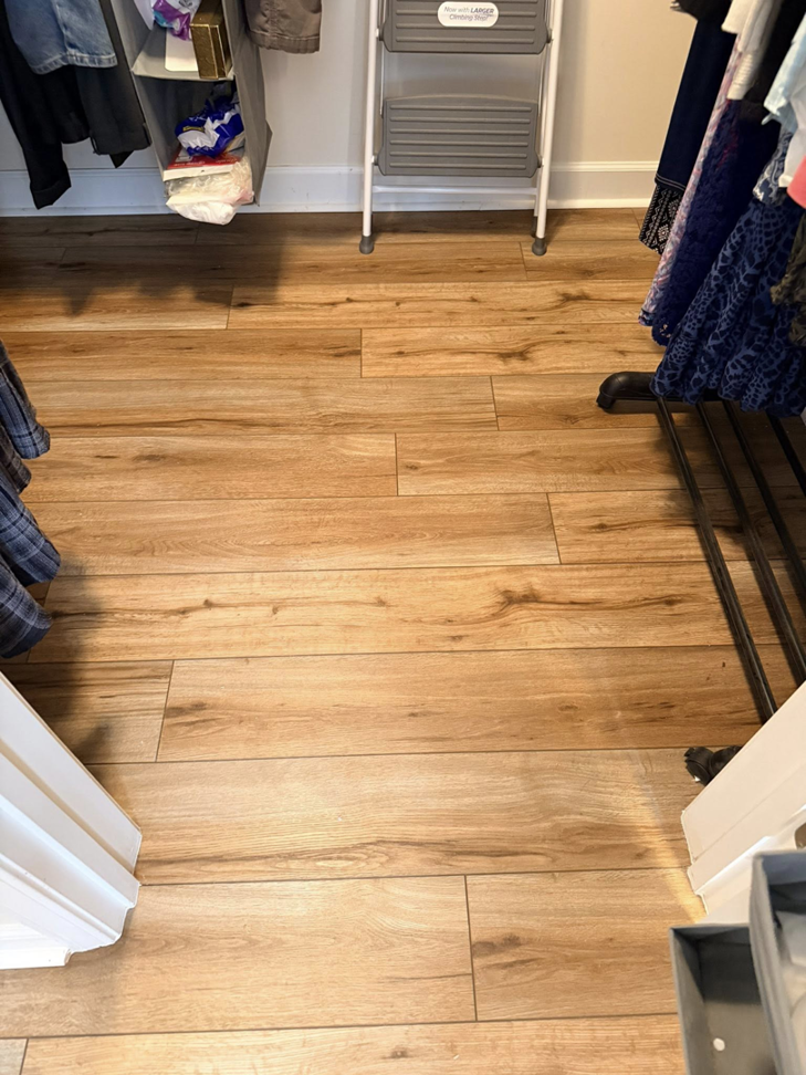 Newly installed wood-look plank flooring in a closet by Master Renovations LLC in Englewood, CO.