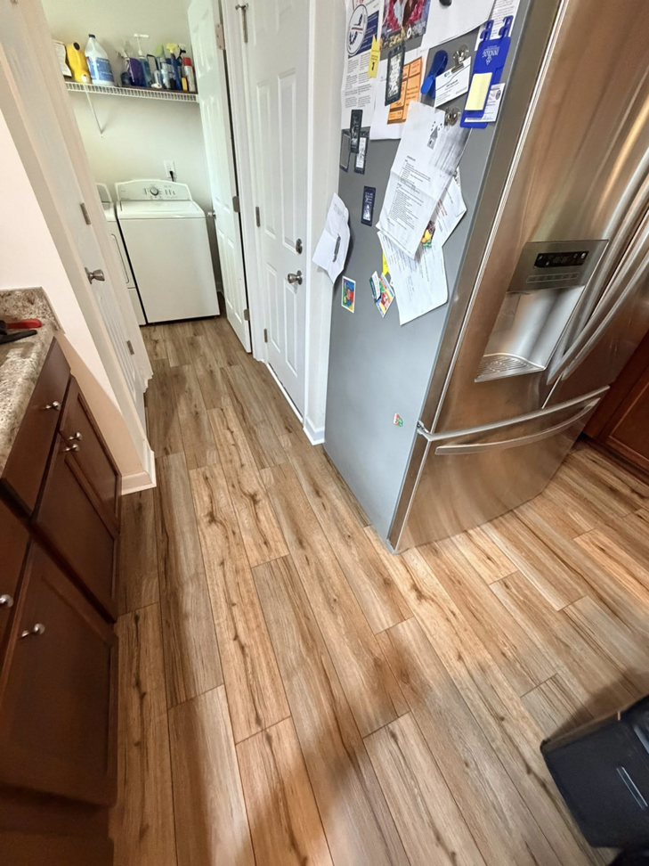 New wood-look plank flooring in a kitchen and laundry room hallway by Master Renovations LLC in Englewood, CO.