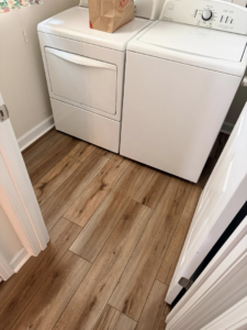 Clean wood-look plank flooring installed in a laundry room by Master Renovations LLC in Englewood, CO.