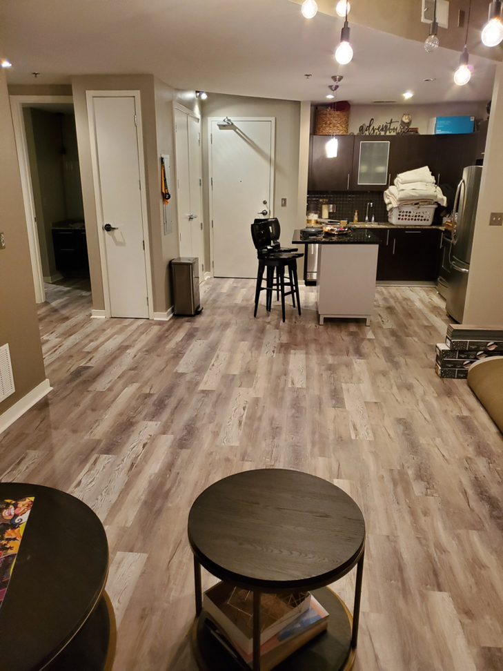 A spacious living room featuring newly installed wood-look laminate flooring by J & J Home Improvements, LLC in Franklin, TN.