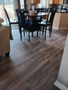 A newly installed wood-look tile floor in a dining area by Home Improvement Design Center in Ann Arbor, MI.