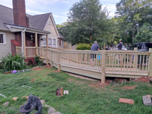 A newly constructed wooden accessibility ramp and deck leading to a house by Vest Home Services LLC in Greenville, SC.