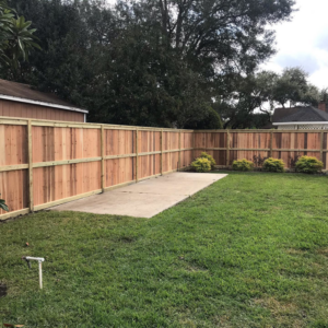 A newly installed wooden fence enclosing a backyard, showcasing work by Rob the Roofer in Houston, TX.