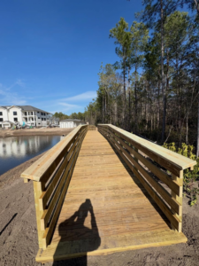 A newly constructed wooden boardwalk next to a pond, built by Coastal Dock and Resurfacing in Beaufort, SC.