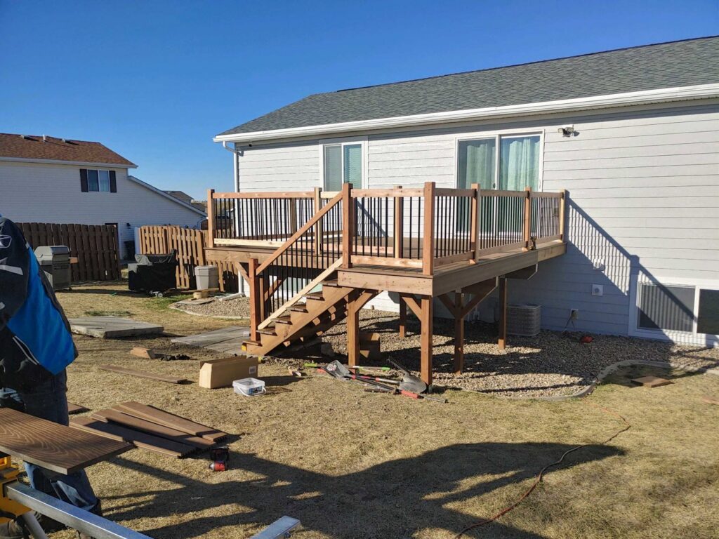 A newly constructed wooden deck with stairs, showing a completed outdoor renovation project by Rapid Renovations LLC in Rapid City, SD.