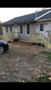Newly constructed wooden decks and porches on a house exterior by Two Girls Cleaning Services in Brunswick, ME.