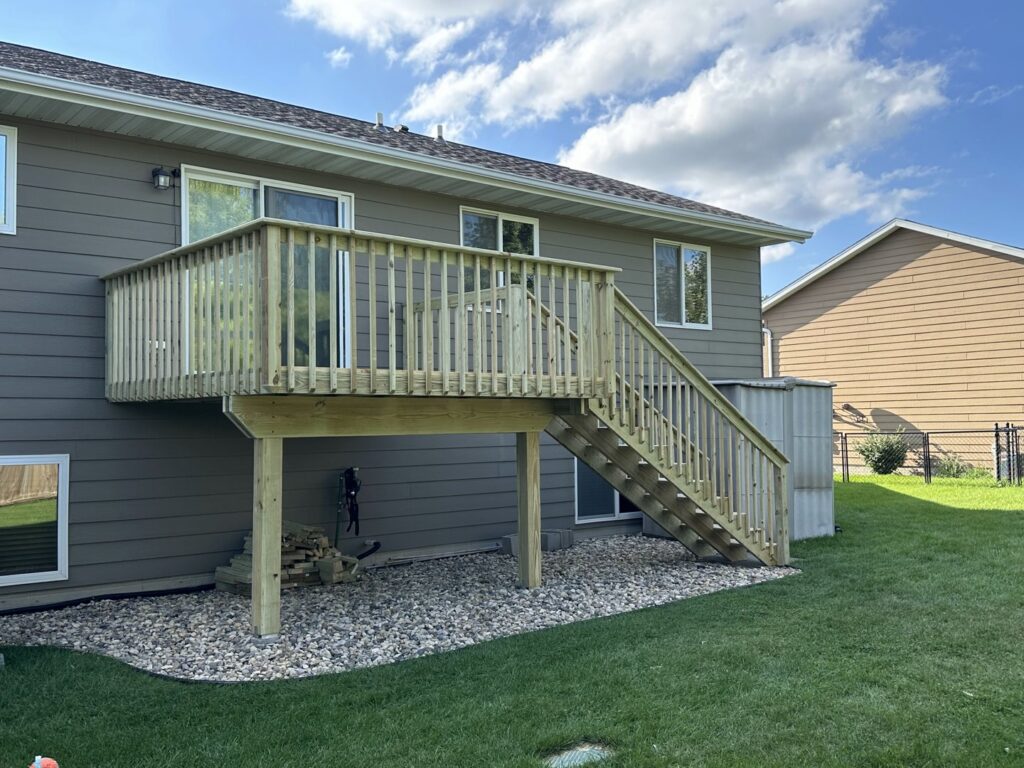 A newly constructed wooden deck with stairs, expertly installed by Dakota Small Jobs in Sioux Falls, SD.