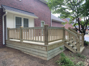 A newly installed wooden deck with stairs leading to a backyard, built by Matt Hingle Construction in Bowling Green, KY.