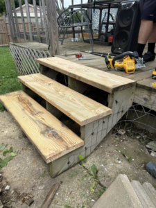 Installation of a new wooden deck staircase with tools nearby, performed by A2 Construction in Louisville, KY.