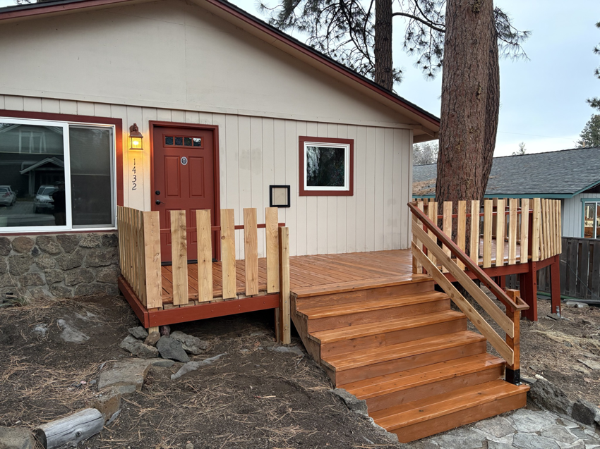 A newly constructed wooden deck and stairs leading to a home entrance, built by Handy Home Hero LLC in Bend, OR.