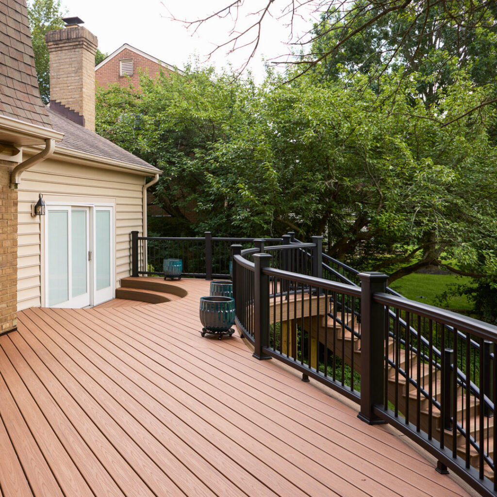 A newly constructed wooden deck with stairs on the side of a house, built by Four Seasons Home Improvement Company, Inc. in Rockville, MD.