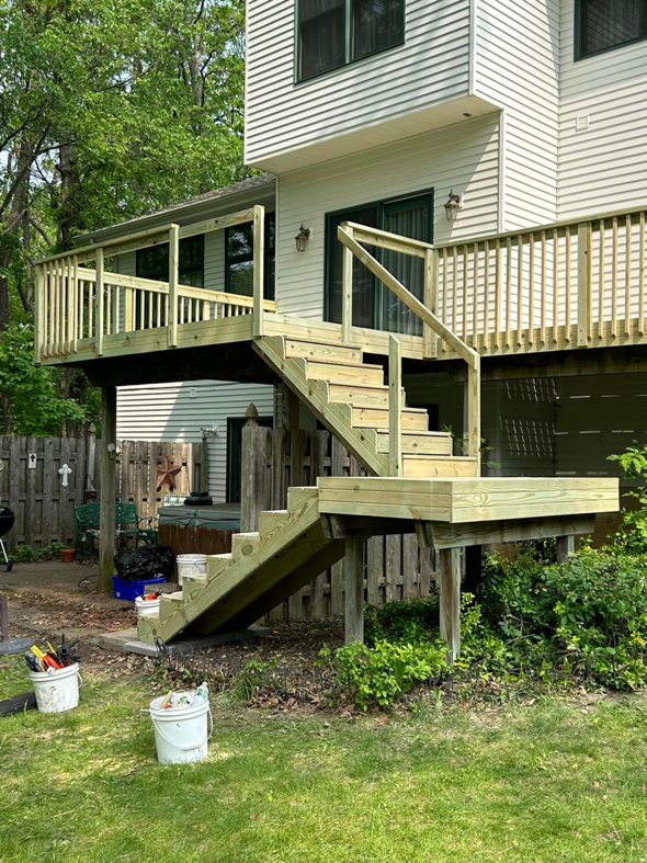 A new wooden deck and stairs with tools on the ground, built by Aaron's Handyman Service in Tucson, AZ.