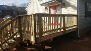 A newly constructed wooden deck with stairs and railings attached to a home by Fence Me In And Decks Too in Glen Allen, VA.