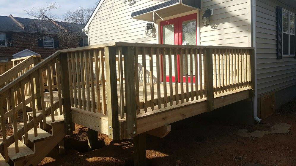 A newly constructed wooden deck with stairs and railings attached to a home by Fence Me In And Decks Too in Glen Allen, VA.