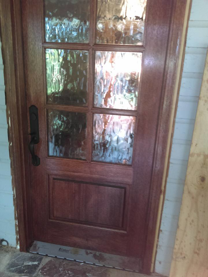 A newly installed wooden door with decorative glass panels by Fryes Renovation and Improvements in Johnson City, TN.