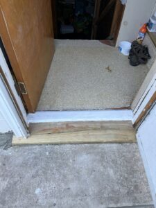 Installation of a new wooden door threshold at an entryway by CJP Construction handyman services in Pierce, NE.