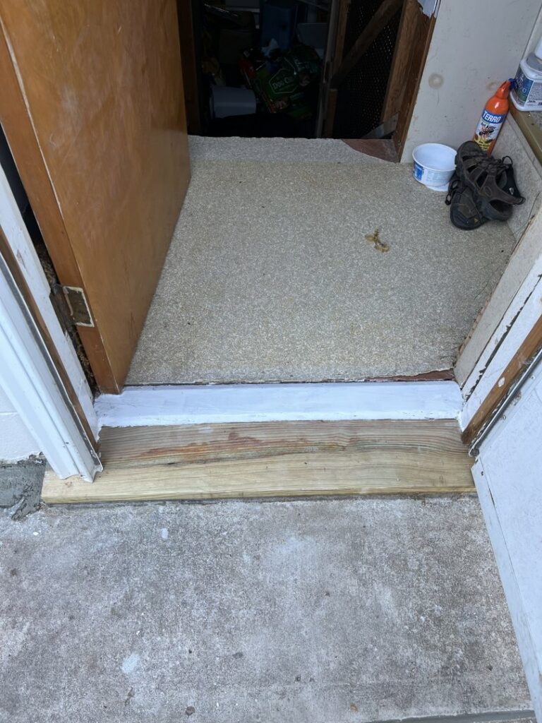 Installation of a new wooden door threshold at an entryway by CJP Construction handyman services in Pierce, NE.