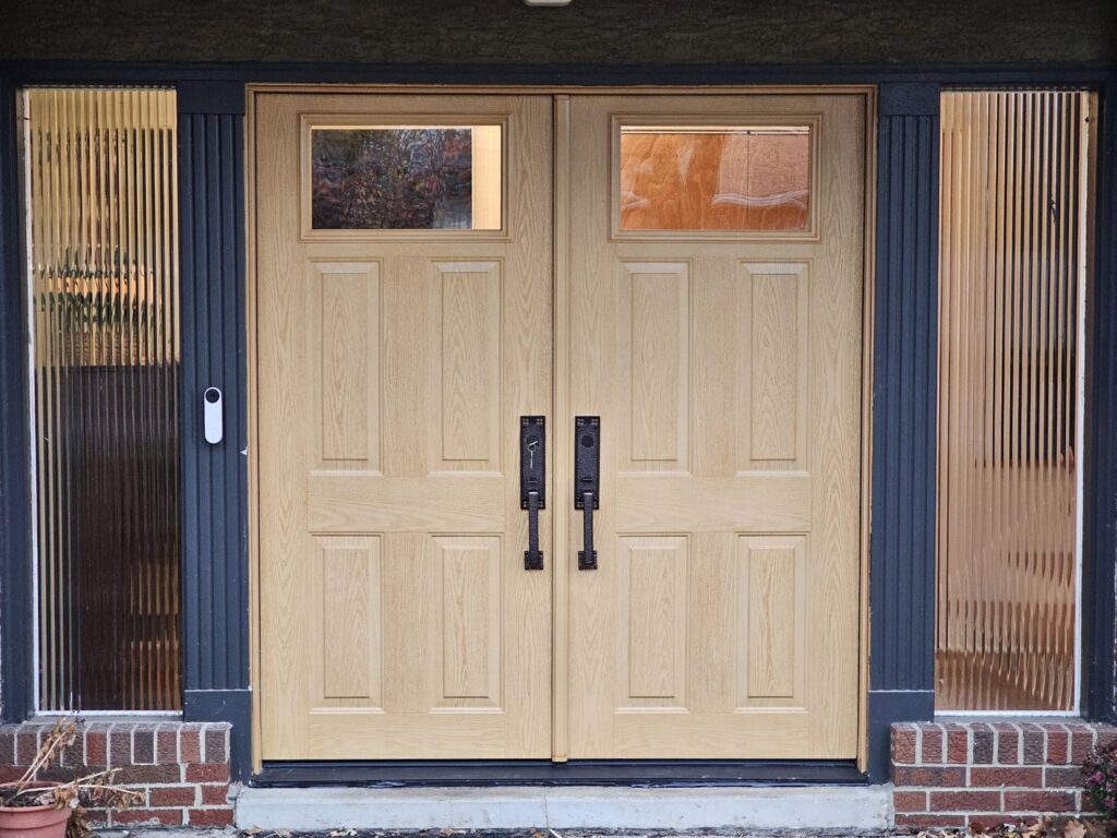 A newly installed wooden double door with decorative side panels by The Window Man of Ohio in Westerville, OH.