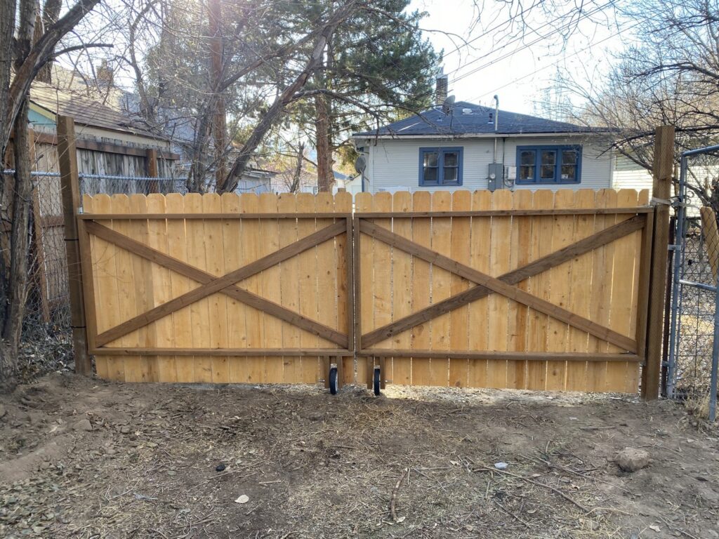 Newly installed wooden double gate with decorative X-bracing, a fence and gate service by No Delay SVCS in Pocatello, ID.