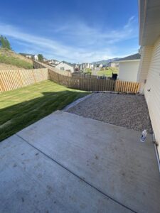Newly installed wooden fence and gravel landscaping in a backyard, a service provided by No Delay SVCS in Pocatello, ID.