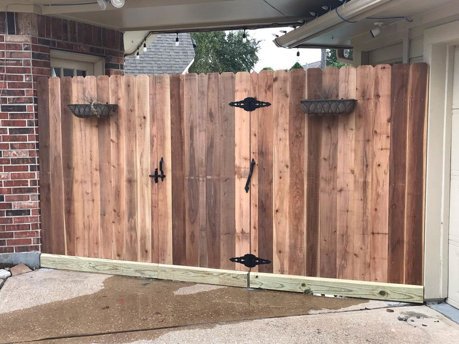 A newly installed wooden fence gate with fresh lumber, a construction project by Rob the Roofer in Houston, TX.