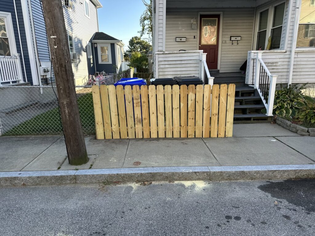 Newly installed wooden fence section along a sidewalk by CWS Handyman LLC in Seekonk, MA