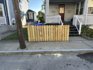 Newly installed wooden fence section along a sidewalk by CWS Handyman LLC in Seekonk, MA