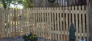A newly installed wooden picket fence with a gate by Handyashby in Saint Joseph, MO.