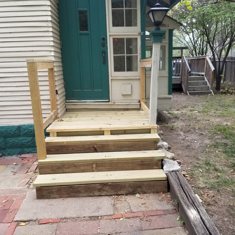 Newly constructed wooden porch and steps by Chris's Handyman Services in Wichita, KS