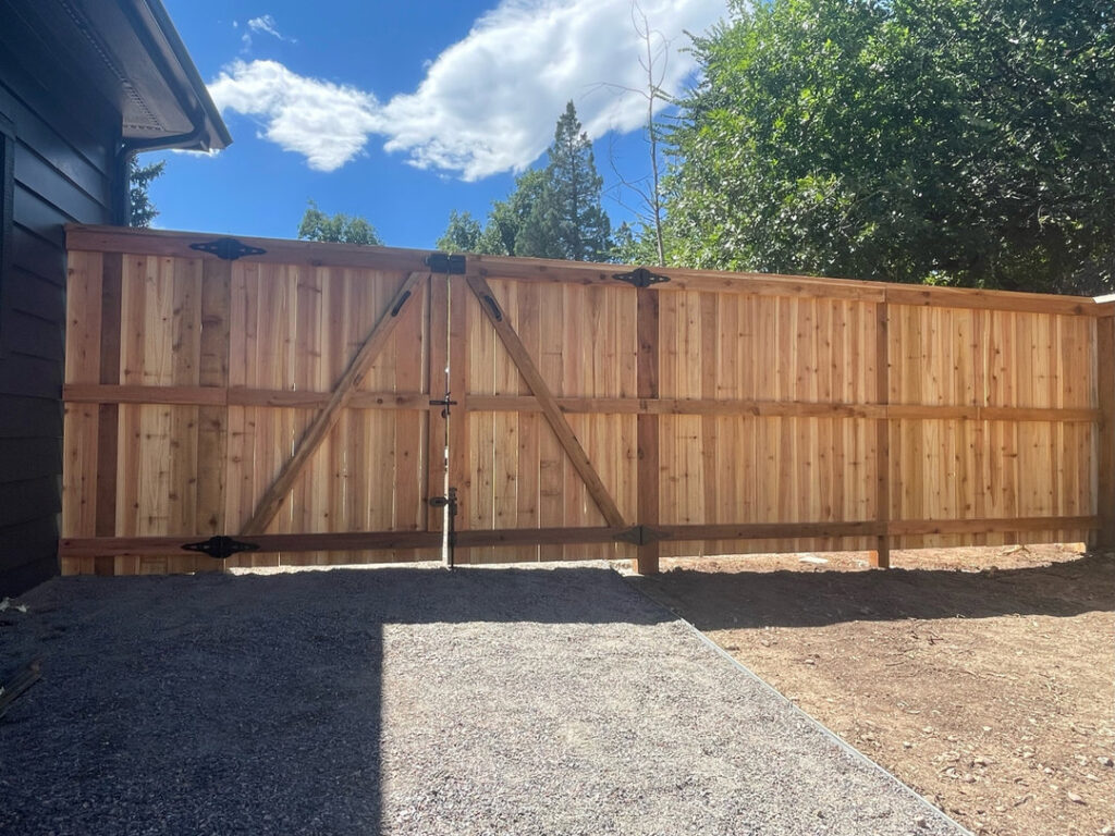 A newly installed wooden privacy fence with a matching gate by GreenView Solutions in Denver, CO.