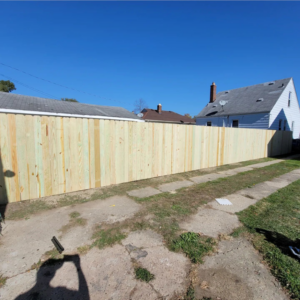 A newly installed wooden privacy fence in a backyard by Del Rey Properties LLC in Dearborn, MI.