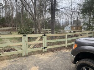 A newly installed wooden split rail fence with wire mesh and a double gate by Premier Fence Company in Glen Allen, VA.