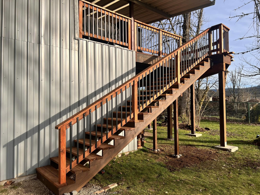 A newly constructed outdoor wooden staircase with railings by One Up construction llc in Springfield, OR.