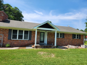 The exterior of a brick house with a newly added or renovated front porch and entryway by WHE Construction in Virginia Beach, VA