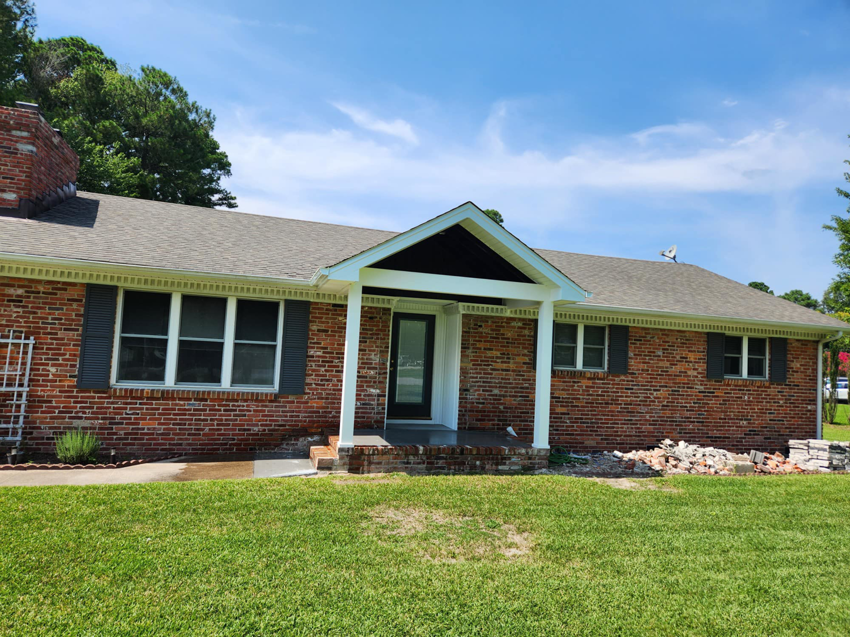 The exterior of a brick house with a newly added or renovated front porch and entryway by WHE Construction in Virginia Beach, VA