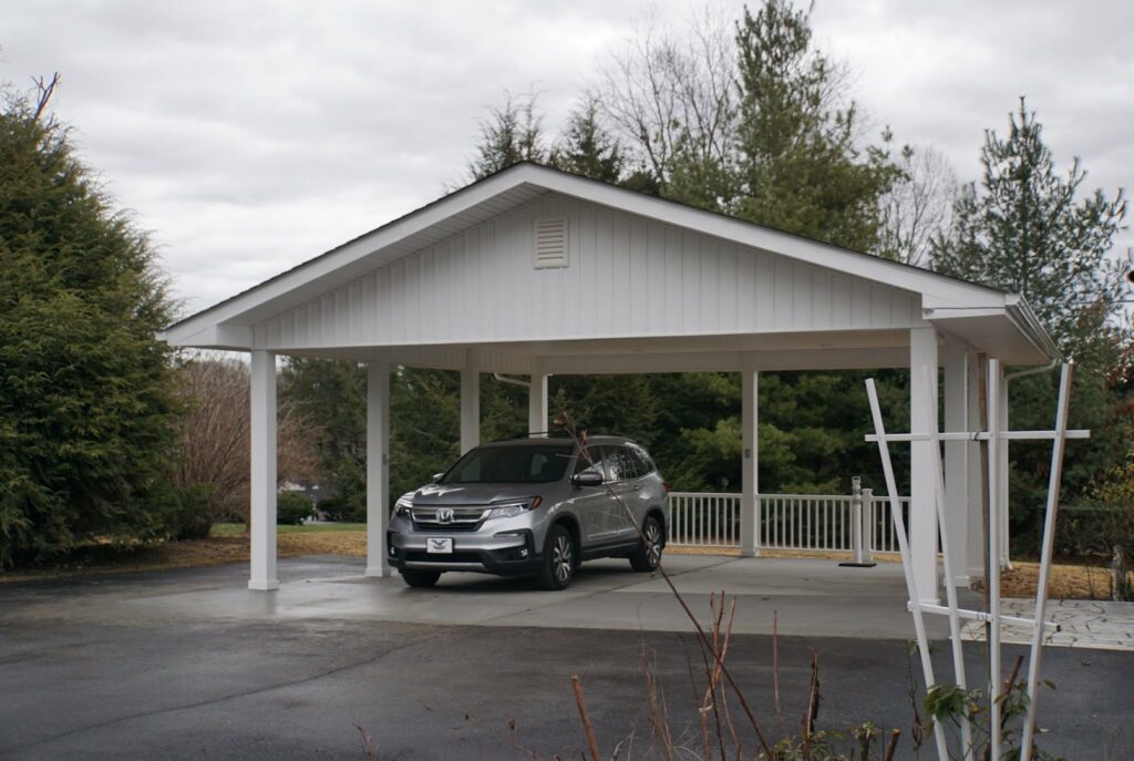 A newly built white carport providing shelter for a vehicle, constructed by Technically Aesthetic General Contractors in Johnson City, TN.