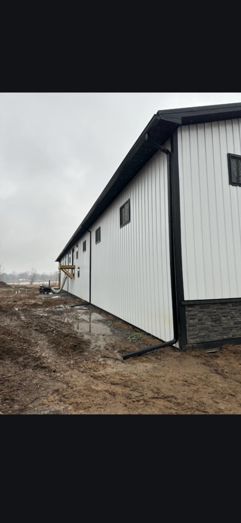The exterior of a newly built commercial building with white siding and black trim by J and R Contracting in Buffalo, NY.