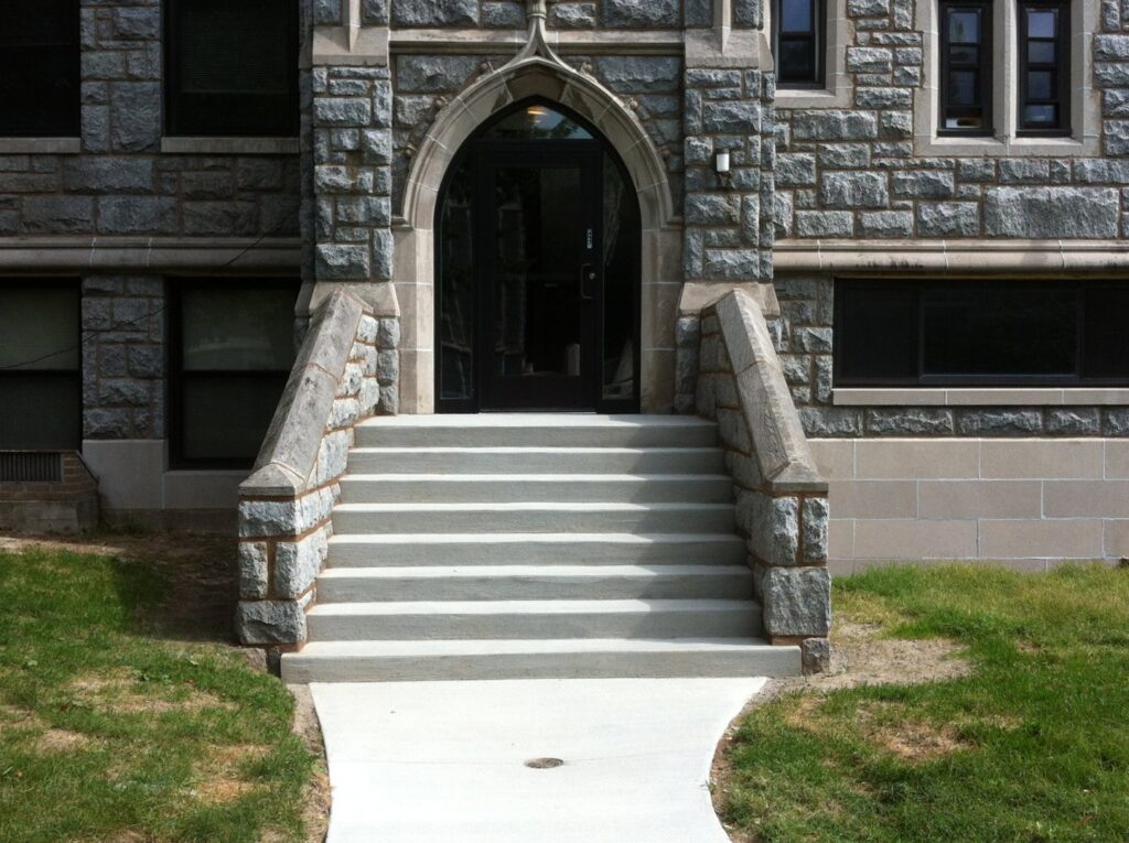 Newly built concrete steps and walkway leading to a stone building entrance by Paris Brothers & Company, Inc in Erie, PA