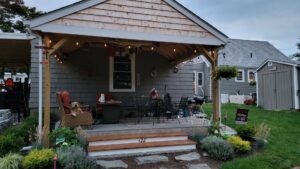 A newly built covered patio with string lights by Wood Trades LLC in Westport, MA.