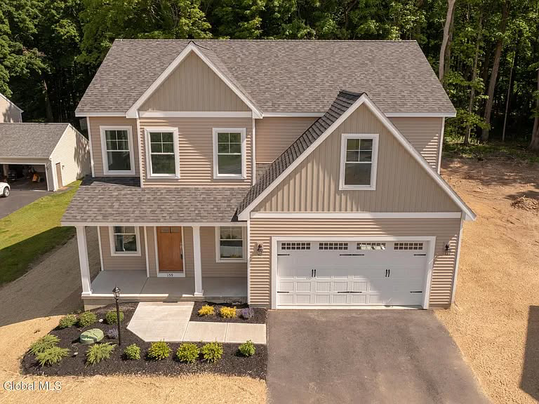 An aerial view of a newly built custom home with beige siding and a two-car garage by McDonald Custom Homes in Schenectady, NY.