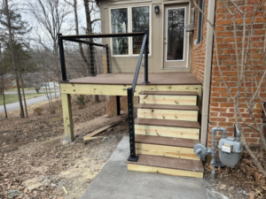 Side view of a newly built deck with wooden stairs and cable railings by IWork Home Services in Greensboro, NC.