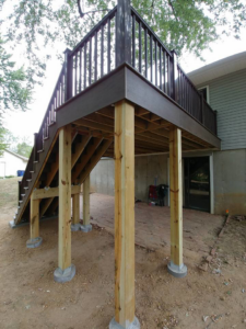 A newly constructed outdoor deck showing its wooden support structure and stairs, built by Custom Remodeling Inc. in Houston, TX.