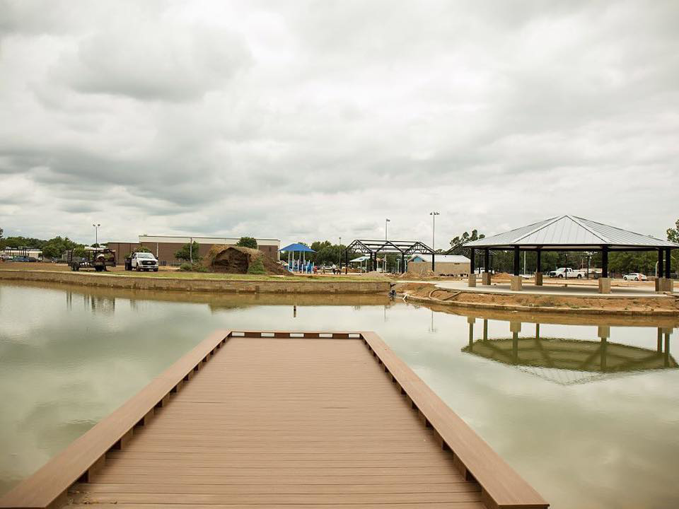 A newly built wooden dock extending into a pond with a gazebo in the background, a project by Northstar Construction, LLC in Fort Worth, TX