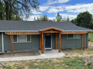 A newly built wooden front entryway and pergola structure on a house, completed by JJT Construction in Portland, OR.