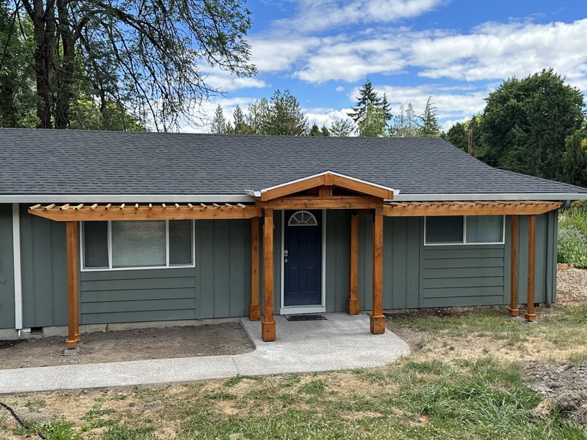 A newly built wooden front entryway and pergola structure on a house, completed by JJT Construction in Portland, OR.