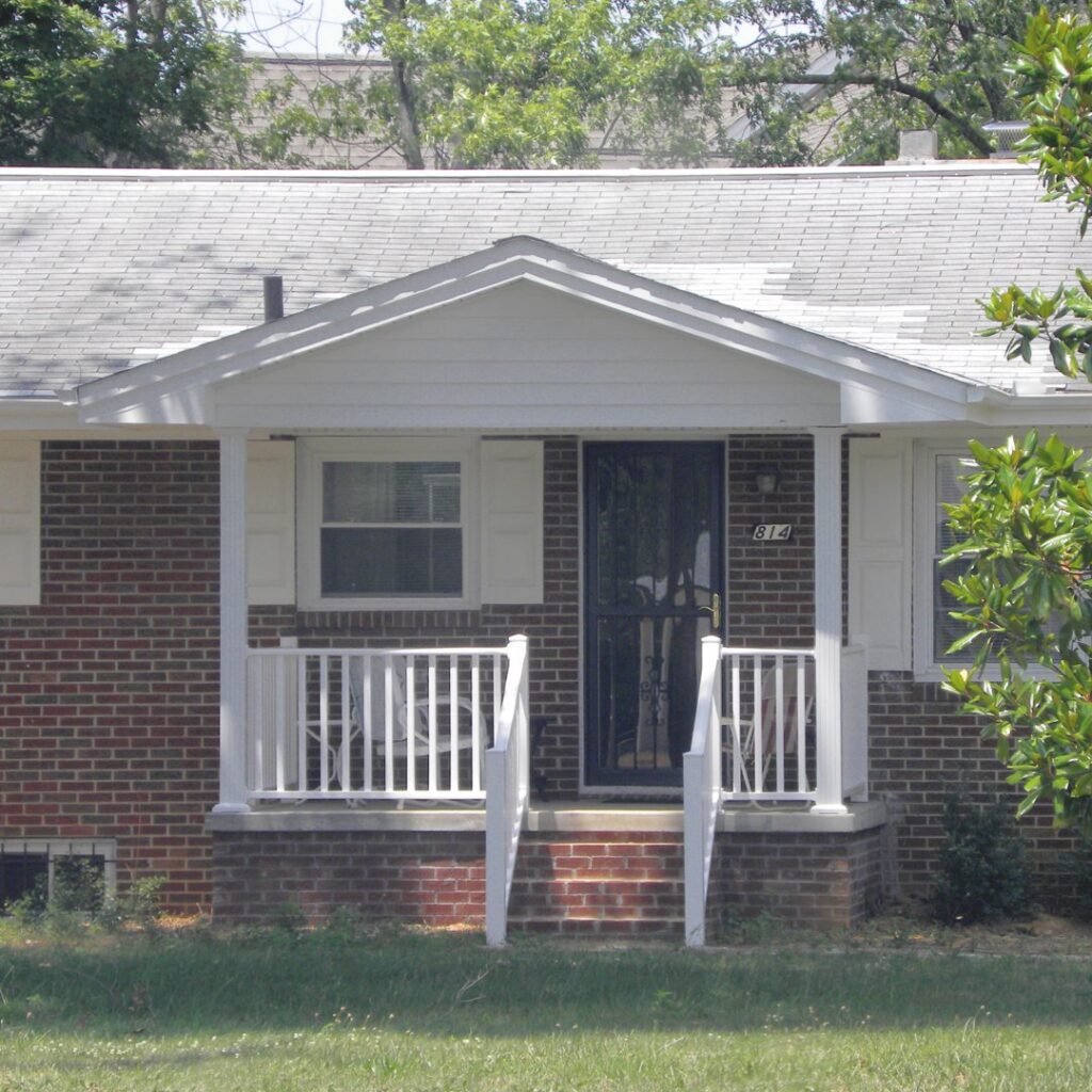 A newly constructed front porch with white railings on a brick house by B & L Builders in Jonesborough, TN