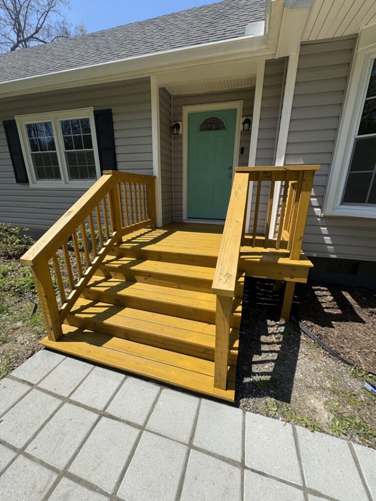 Newly built and stained wooden front porch steps by Sanchez & Hall Construction in Richmond, VA.